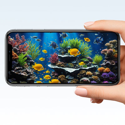 A hand holds a smartphone displaying a vibrant aquarium scene with colorful fish and corals.
